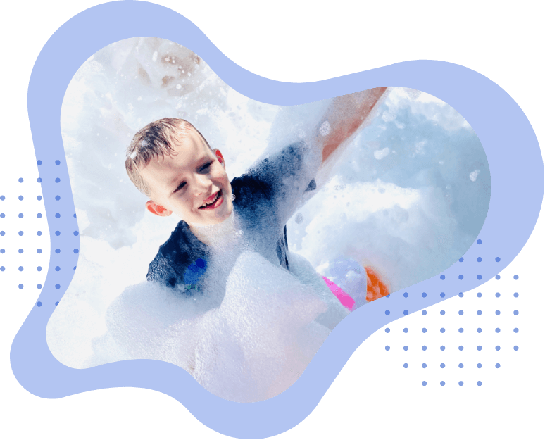 Boy with blue shirt at a foam party.